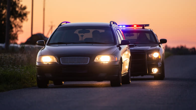 Car pulled over by police vehicle at sunset