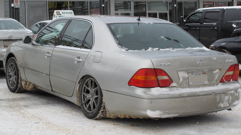 rear view of a silver 2003 Lexus LS in the snow with its rear suspension collapsed
