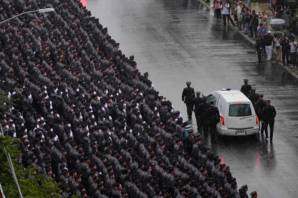 New York Police officers salute as the hearse carries the casket (Copyright 2025 The Associated Press. All rights reserved.)