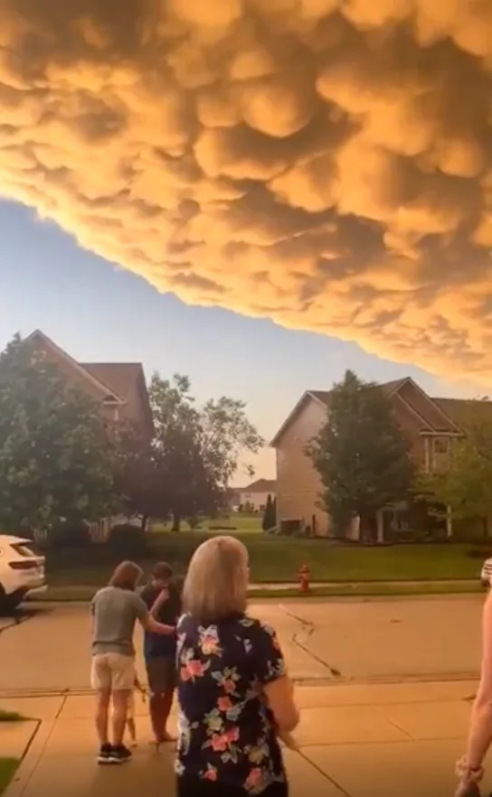 Group of people looking at dramatic, textured cloud formation in a suburban neighborhood