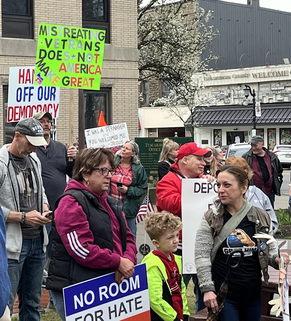 Protesters hold up signs during a recent rally against the policies of the Trump administration.