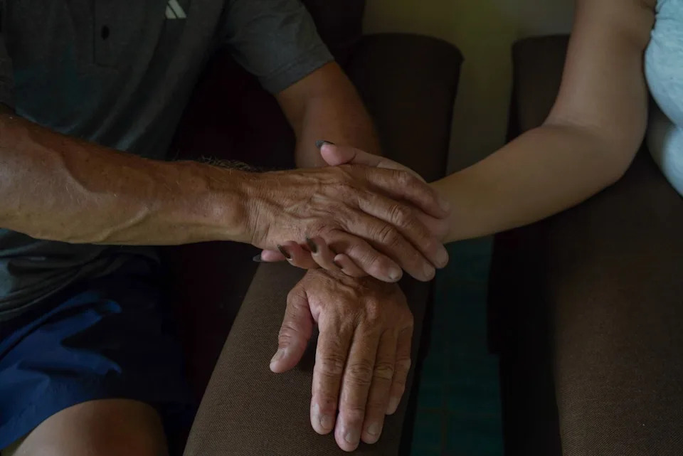 Two people hold hands.