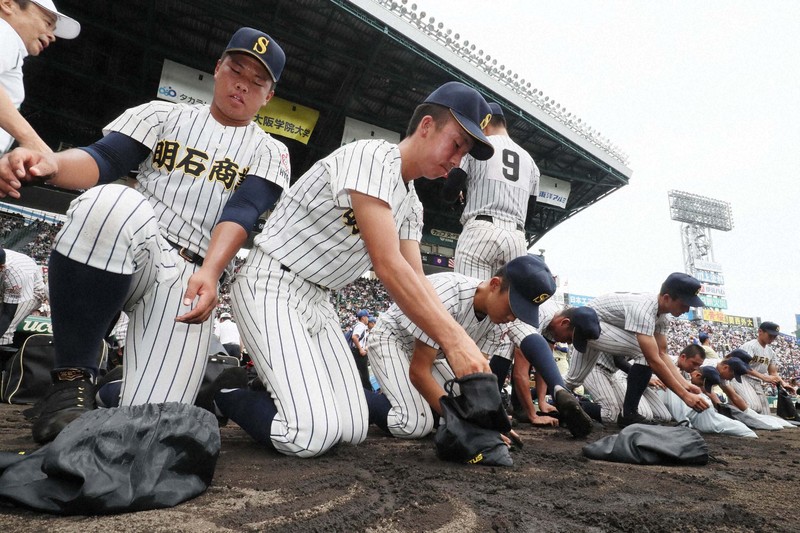 夏の甲子園大会で決勝進出を逃し、グラウンドの土を集める明石商の選手たち＝阪神甲子園球場で2019年8月20日、幾島健太郎撮影