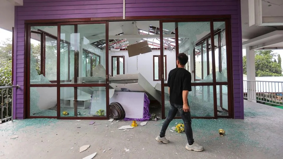 A Thai bystander looks at the damage to Phanom Dong Rak hospital after Cambodia fired on Thailand's Surin province. - Sunny Chittawil/AP