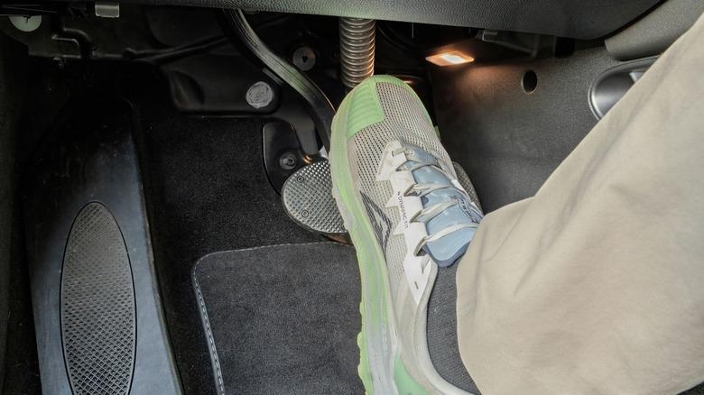 Driver's foot pressing on the brake pedal
