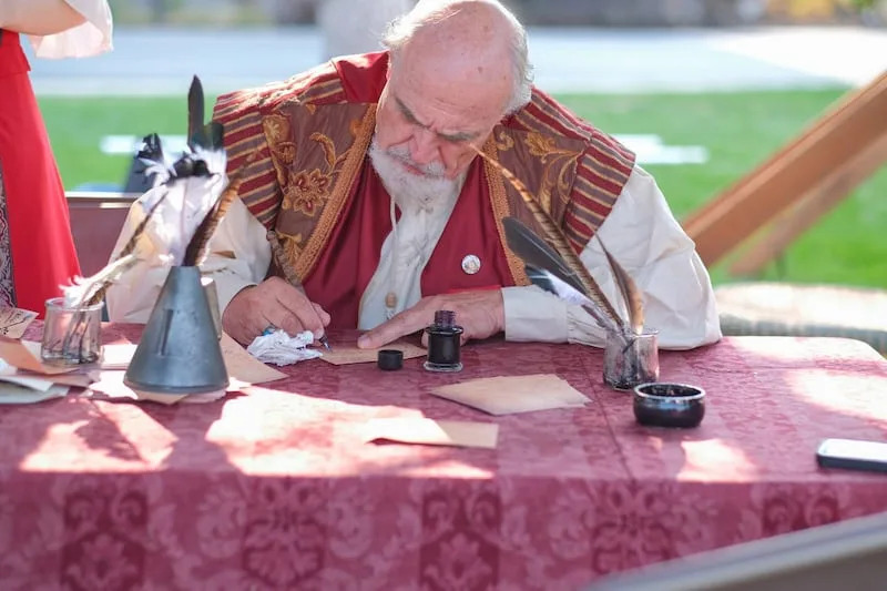 King Henry writes out a quest at the the Utah Renaissance Faire. The 13th annual festival will be this weekend at the Mt. Nebo Botanical Farm in Mona. | Utah Renaissance Faire