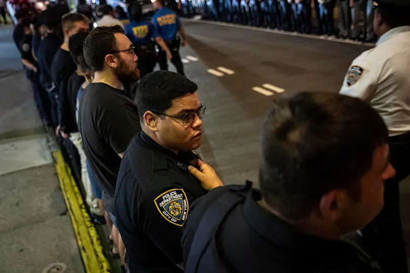 NYPD officers stand in line during the dignified transfer of Didarul Islam, who was shot and killed by a gunman Monday evening, out of NewYork-Presbyterian/Weill Cornell Medical Hospital to the medical examiner's office, early on July 29, 2025, in New York. / Credit: Angelina Katsanis / AP