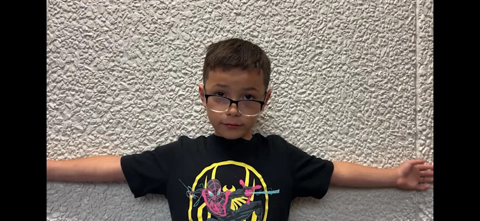 Incoming Westwood Elementary second-grader Ruben Martinez shows readers how big the school library is.