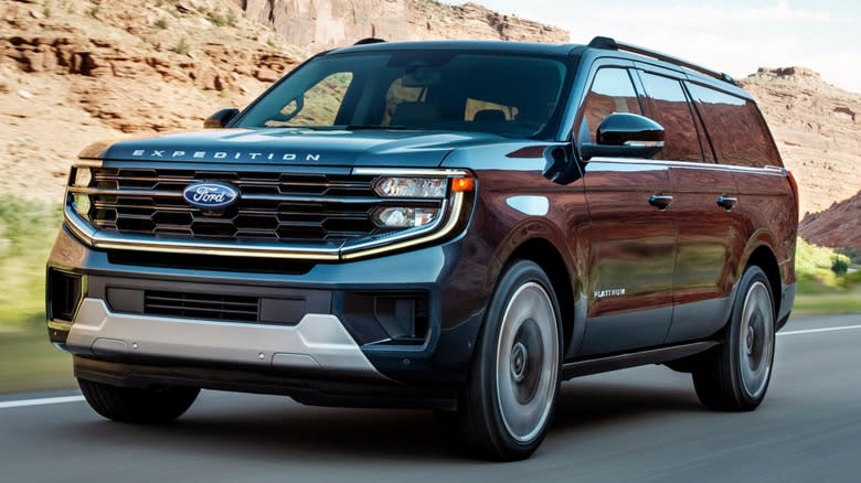 A blue 2025 Ford Expedition on the road through a desert valley
