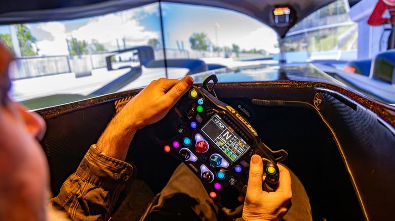 A man driving in a sim racing experience modeled after a Mercedes-AMG F1 car