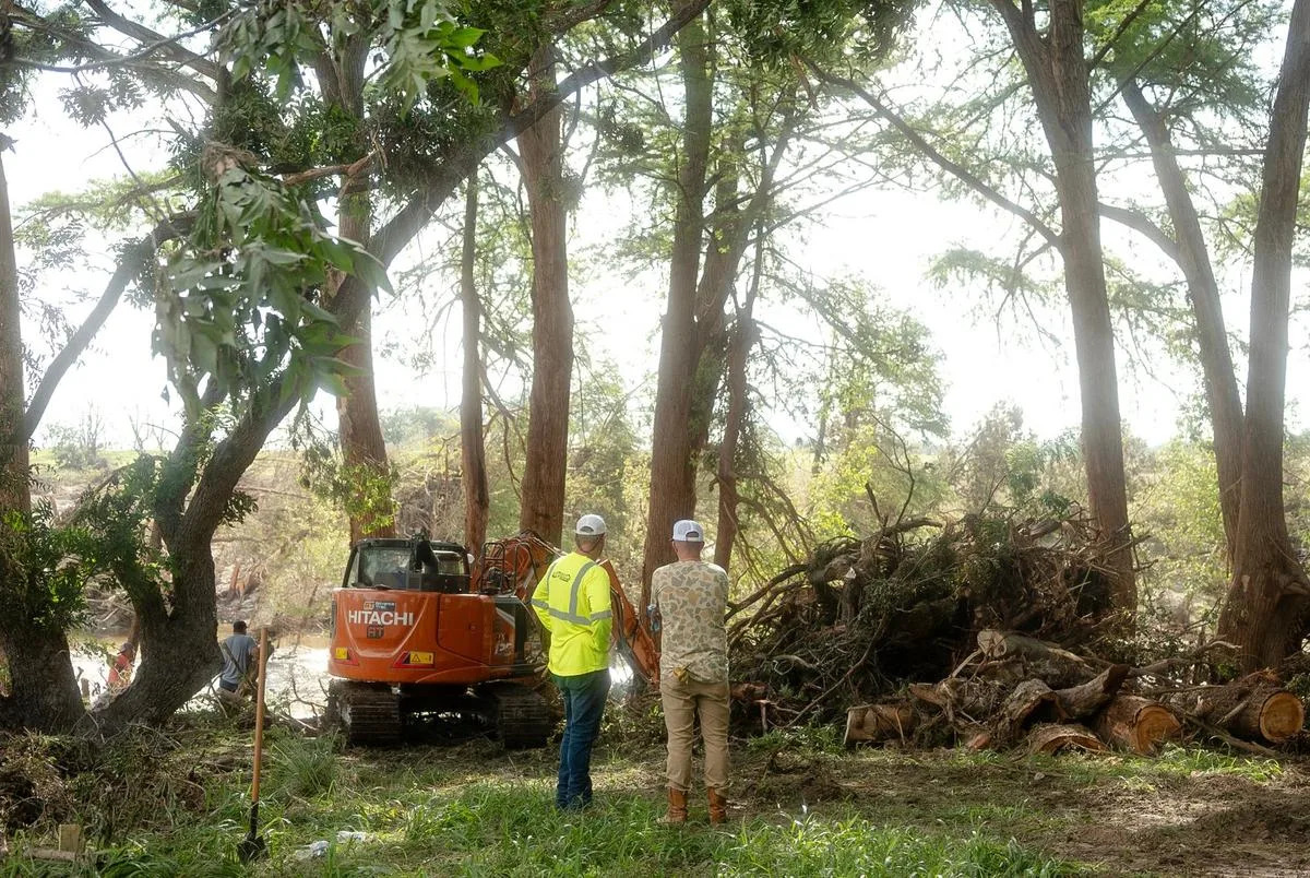 Two men from an excavation company aiding in search and recovery look on to the debris left from the flood in Center Point on Tuesday July 8, 2025.