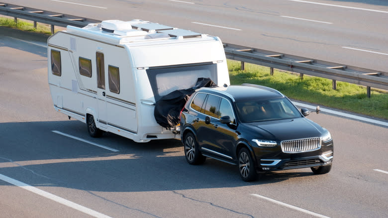A Volvo SUV pulling an RV trailer home
