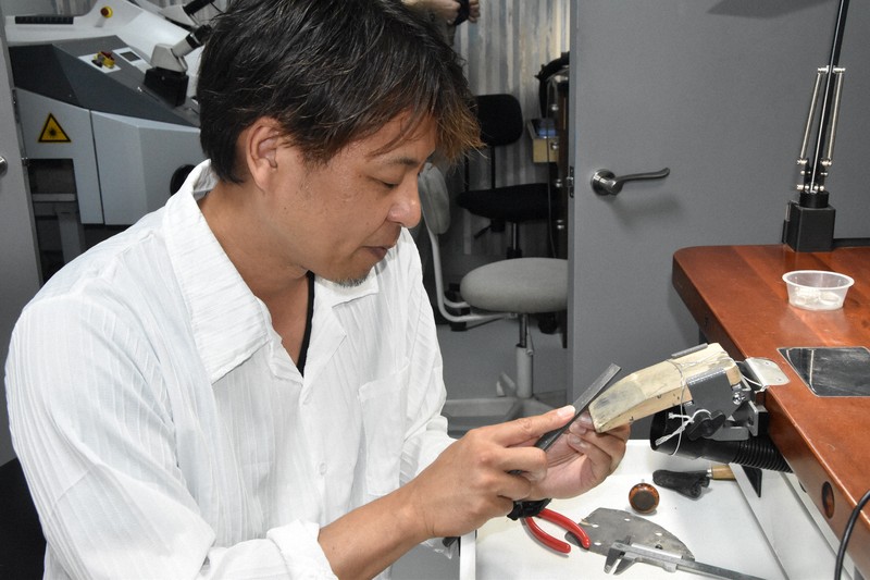 専用の機材で貴金属を研磨する後藤晃一さん。一つ一つ手作業で磨いていく＝甲府市で2025年7月2日午前10時56分、杉本修作撮影