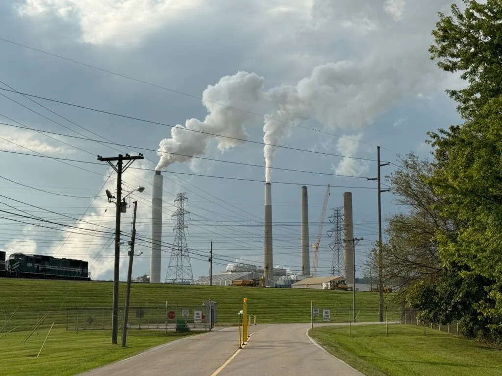 Emissions billow out of smokestacks in the distance at the power plant.