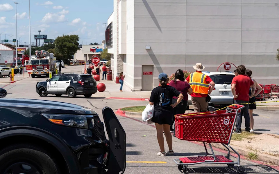 People look on as police attend the scene at Target in Austin, Texas
