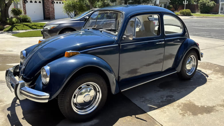 a blue 1970 Volkswagen Beetle parked in a driveway