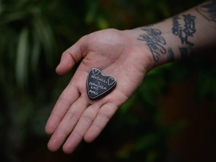 A brown-colored handmade heart displayed on an open palm