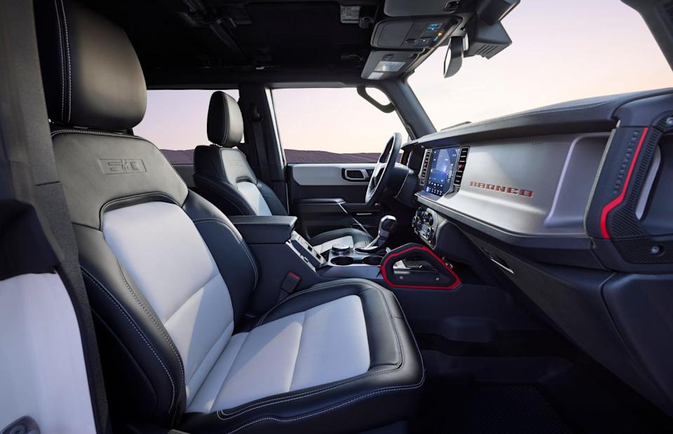 interior view from passenger side showing black and gray seats, touchscreen display, and gear selector.