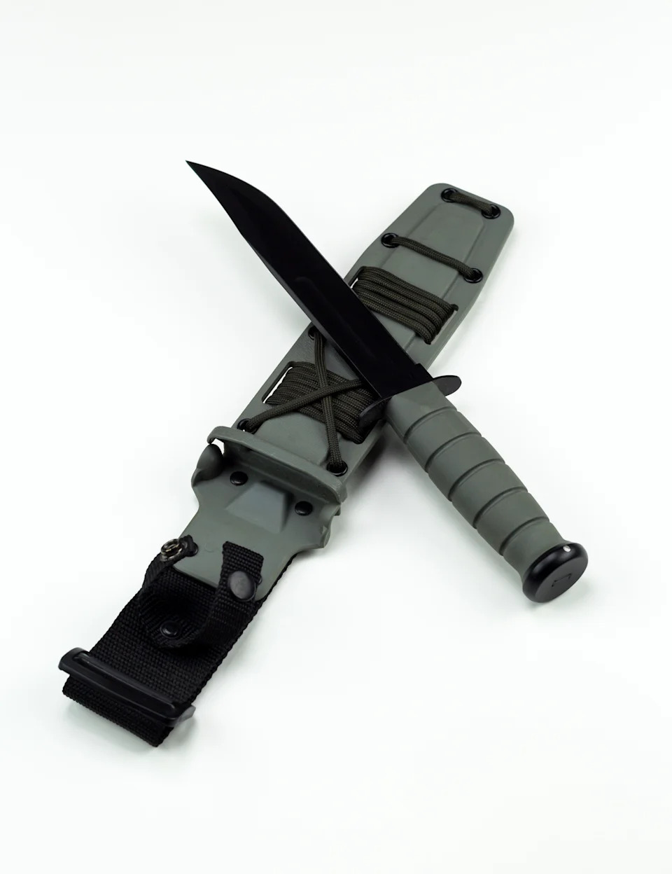 A tactical knife with a green handle and sheath displayed on a white surface