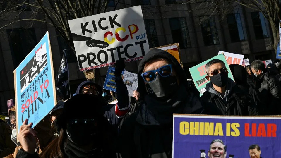 Protesters hold placards during a demonstration outside Royal Mint Court against the proposed site of the new Chinese embassy. - Chris J Ratcliffe/Reuters/file
