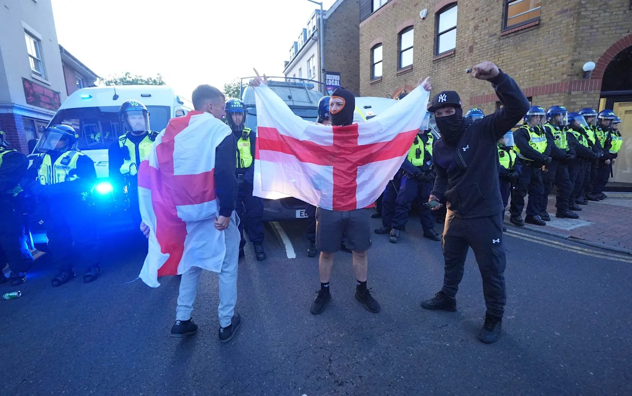 Protestors holding up an England flag during the anti-migrant protests in Epping, Essex