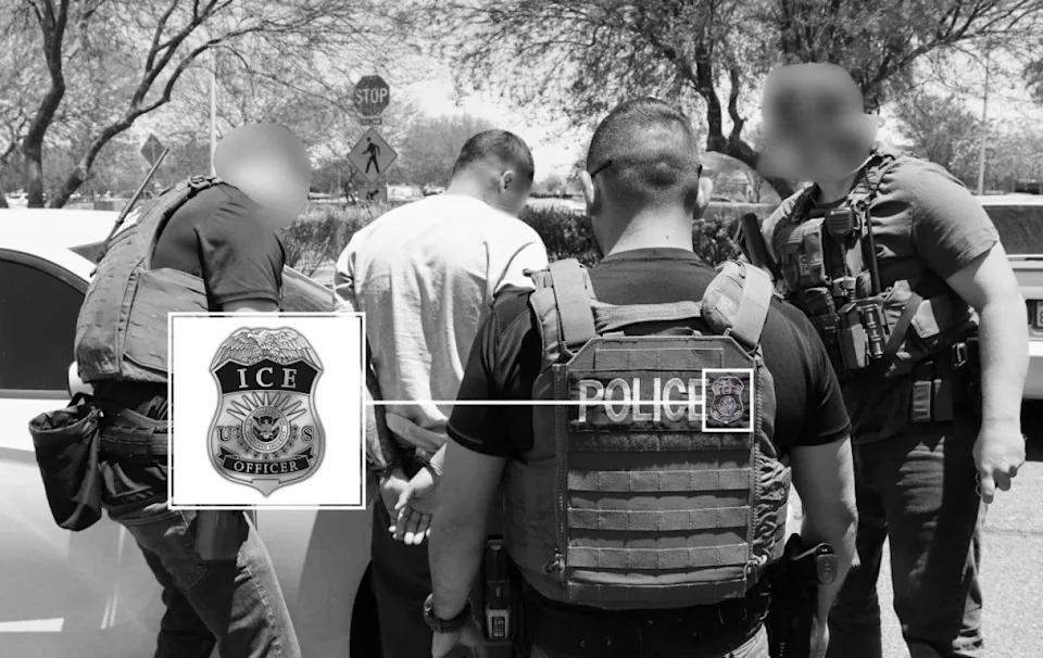 Black and white photo of group of four U.S. Immigration and Customs Enforcement (ICE) officers, wearing tactical vests and armed with weapons, detain a man in a white shirt with his hands cuffed behind his back next to a car. Enlarged inset shows detail of ICE patch on vest. - Photo via U.S. Marshals Service Los Angeles