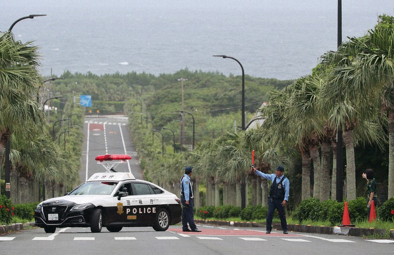 ロシア・カムチャツカ半島付近の地震で津波警報が出され、沿岸部へ入るのを規制する警察官ら＝東京都八丈町で30日午前11時7分、手塚耕一郎撮影