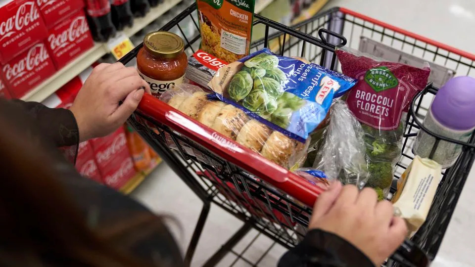 A shopper pushes a cart of groceries at a supermarket in Bellflower, California, in February 2023. - Allison Dinner/AP/File