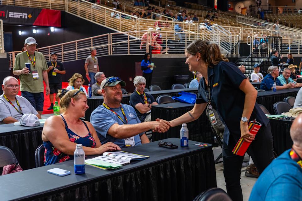 Car enthusiasts interacting at Mecum auto auction.