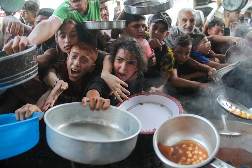 Palestinians gather to receive food cooked by a charity kitchen, amid the Israel-Hamas conflict (REUTERS)