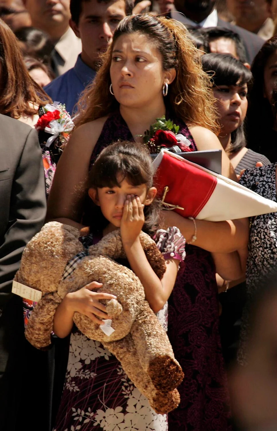 Celeste Escalante, wife of Juan Abel Escalante and their daughter watch as pall bearers walk with the casket of Escalante.