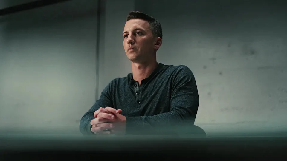 Aaron Quinn sitting in a interrogation room.