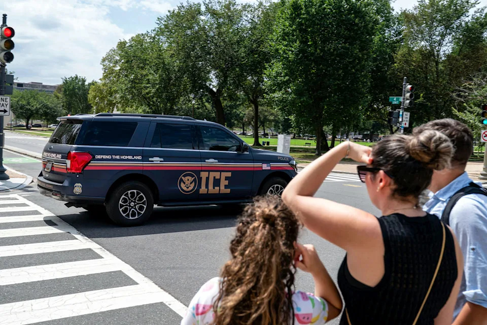An Immigration and Customs Enforcement police SUV patrols on the road as people watch from the sidewalk (Jose Luis Magana / AP)