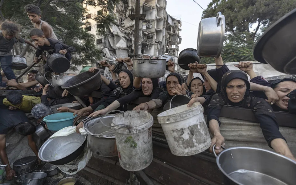 Displaced Palestinians queued for hot meals amid worsening crisis in Gaza