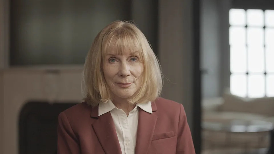 Dr. Katherine Ramsland wearing a coral blazer and white collared blouse.
