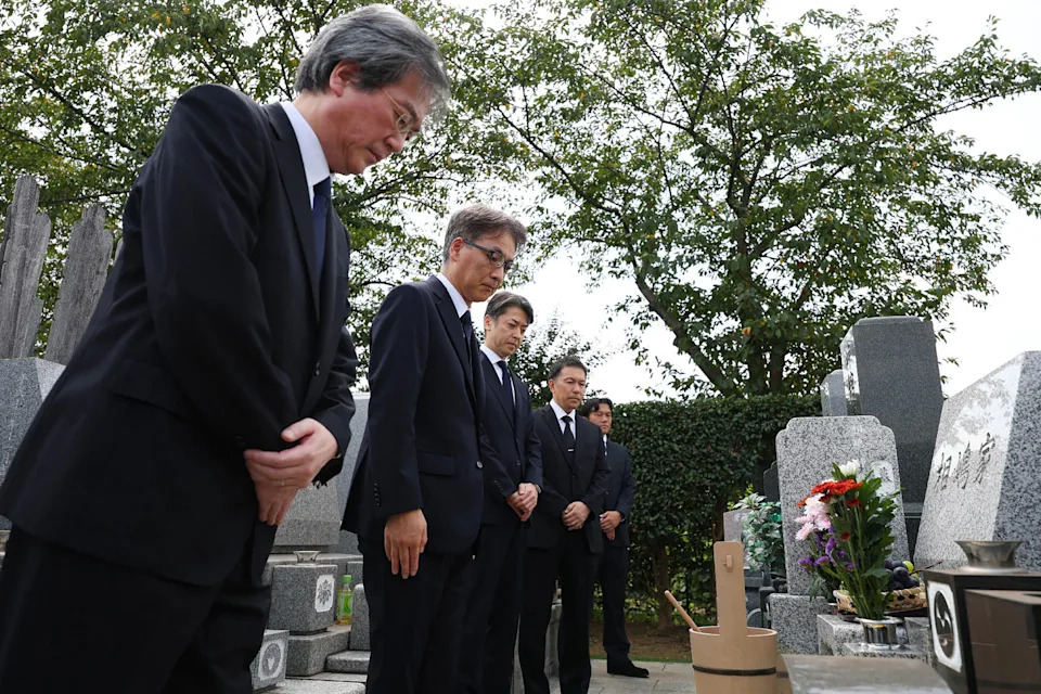 Tetsuro Kamata from Japan's National Police Agency (3rd L) and two other officials from the prosecutor's office apologize in front of the grave of Shizuo Aishima, who was falsely accused of unauthorized export of sensitive equipment and died after prolonged detention, in Yokohama on Aug. 25, 2025. / Credit: STR/JAPAN POOL/JIJI PRESS/AFP via Getty Images