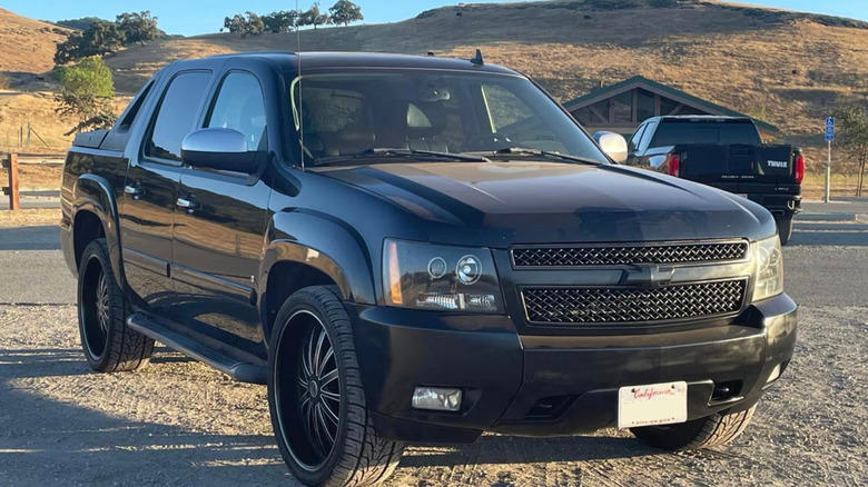 a black 2007 Chevrolet Avalanche LTZ in a gravel parking lot in California