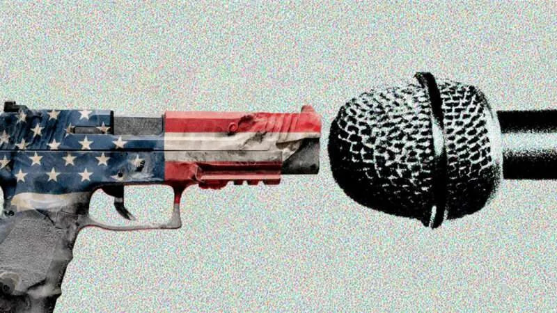 A gun colored by the American flag faces a microphone