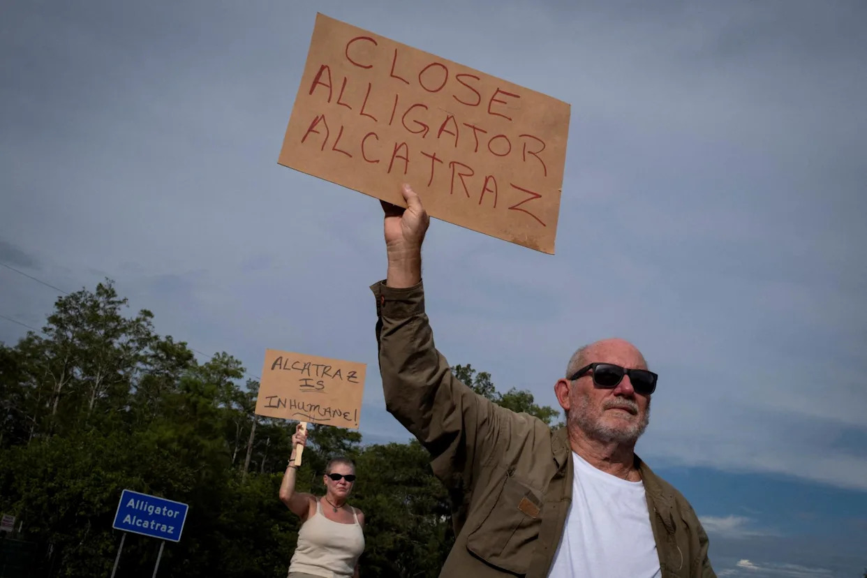 <span>People hold signs during a vigil in support of immigration detainees at the entrance of ‘Alligator Alcatraz’ Icedetention center in Ochopee, Florida, on 10 August.</span><span>Photograph: Marco Bello/Reuters</span>