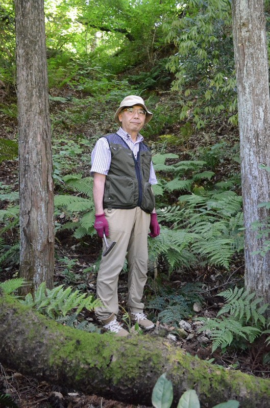 かつてウランが採掘された山肌を案内する橋本悦雄さん＝福島県石川町で2025年6月17日午後2時31分、岩間理紀撮影