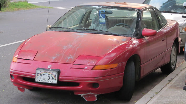A Saturn SC coupe in a state of disrepair