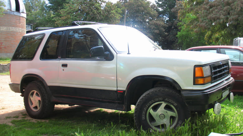 a white 1993 Ford Explorer Sport parked on grass