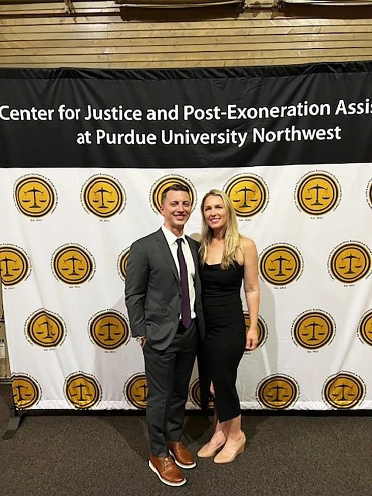 Denise Huskins and Aaron Quinn in formal wear standing at a step-and-repeat.