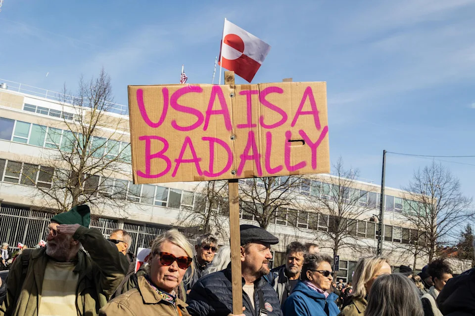 A protester holds a placard saying