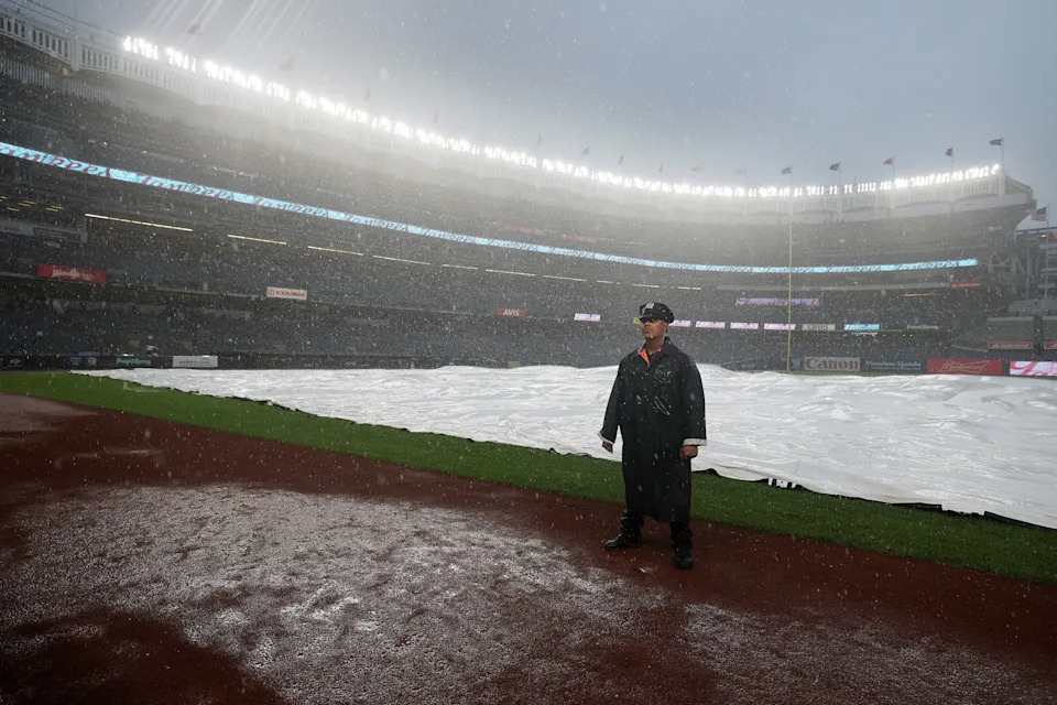 Al Bello/Getty Images - PHOTO: Detective Felipe Ortiz of the New York Police Department stands on the field during a rain delay between the New York Yankees and the Tampa Bay Rays at Yankee Stadium, July 31, 2025, in New York.
