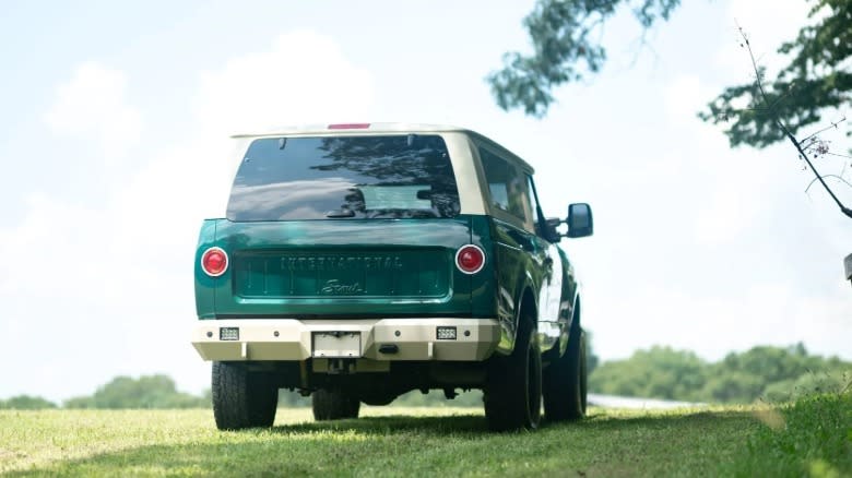 a rear view of the International Scout Nissan Titan build parked omn grass in a field