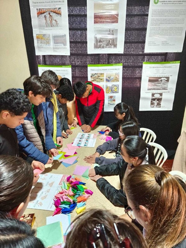パラグアイの都市フラムの「平和展」で折り鶴の作り方を学ぶ現地の若者たち＝河野錫さん提供