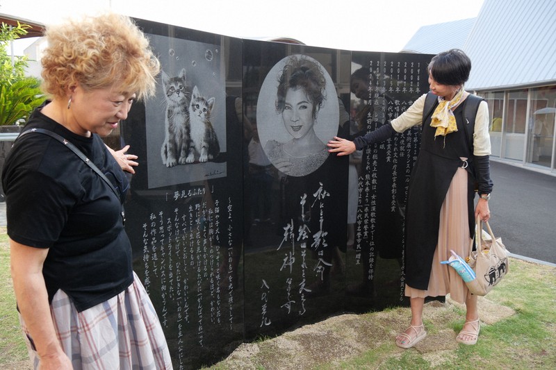 除幕された八代亜紀さんの記念碑に触れるファンの女性ら＝熊本県八代市西松江城町のお祭りでんでん館で2025年8月2日午後5時33分、中村敦茂撮影