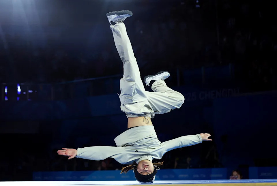 A dancer performs, spinning on their head.