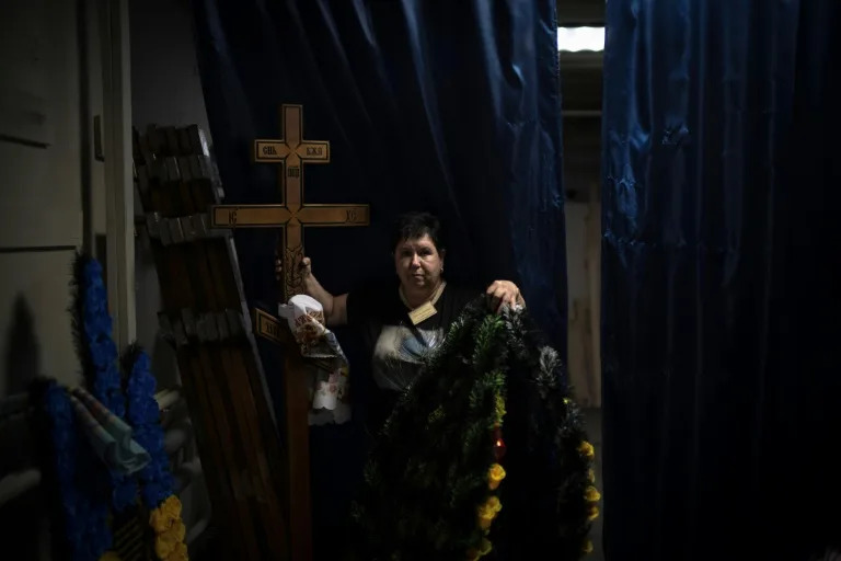Svitlana Ostapenko prepares a cross and wreaths for the funeral of a soldier (Florent VERGNES)